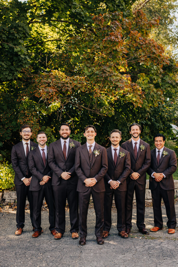 Groom standing with groomsmen in brown suits for a wedding party portrait at The Lageret.