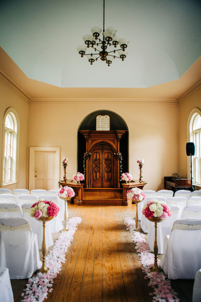 Intimate ceremony setup at Gates of Heaven Madison featuring wooden altar and pink and white floral arrangements.