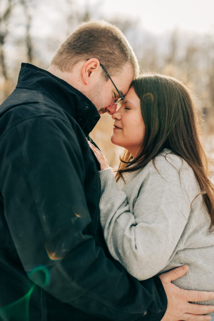 Couple embraced outside during engagement session at Picnic Point