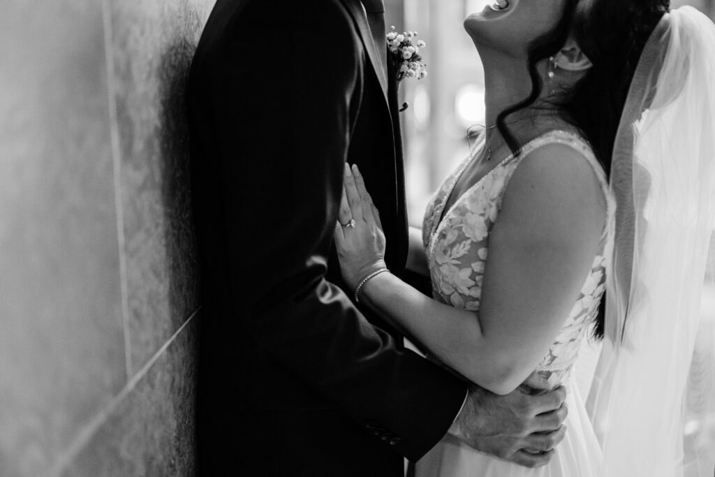 Close-up of bride laughing while holding groom during romantic Wisconsin Capitol wedding portraits.