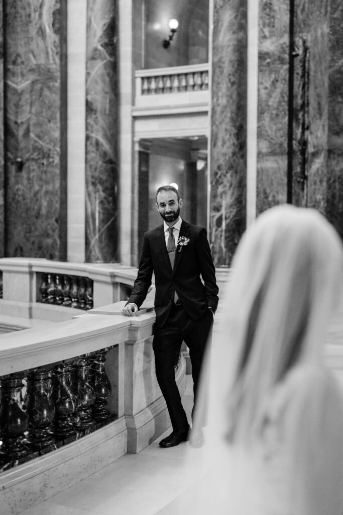 Groom waiting along the Capitol balcony before first look wedding portraits in Madison, Wisconsin.