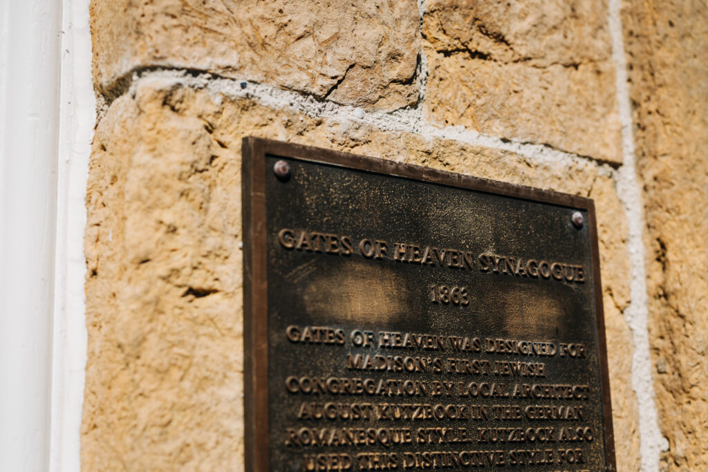 Bronze historical plaque mounted on the stone exterior wall of Gates of Heaven in Madison.