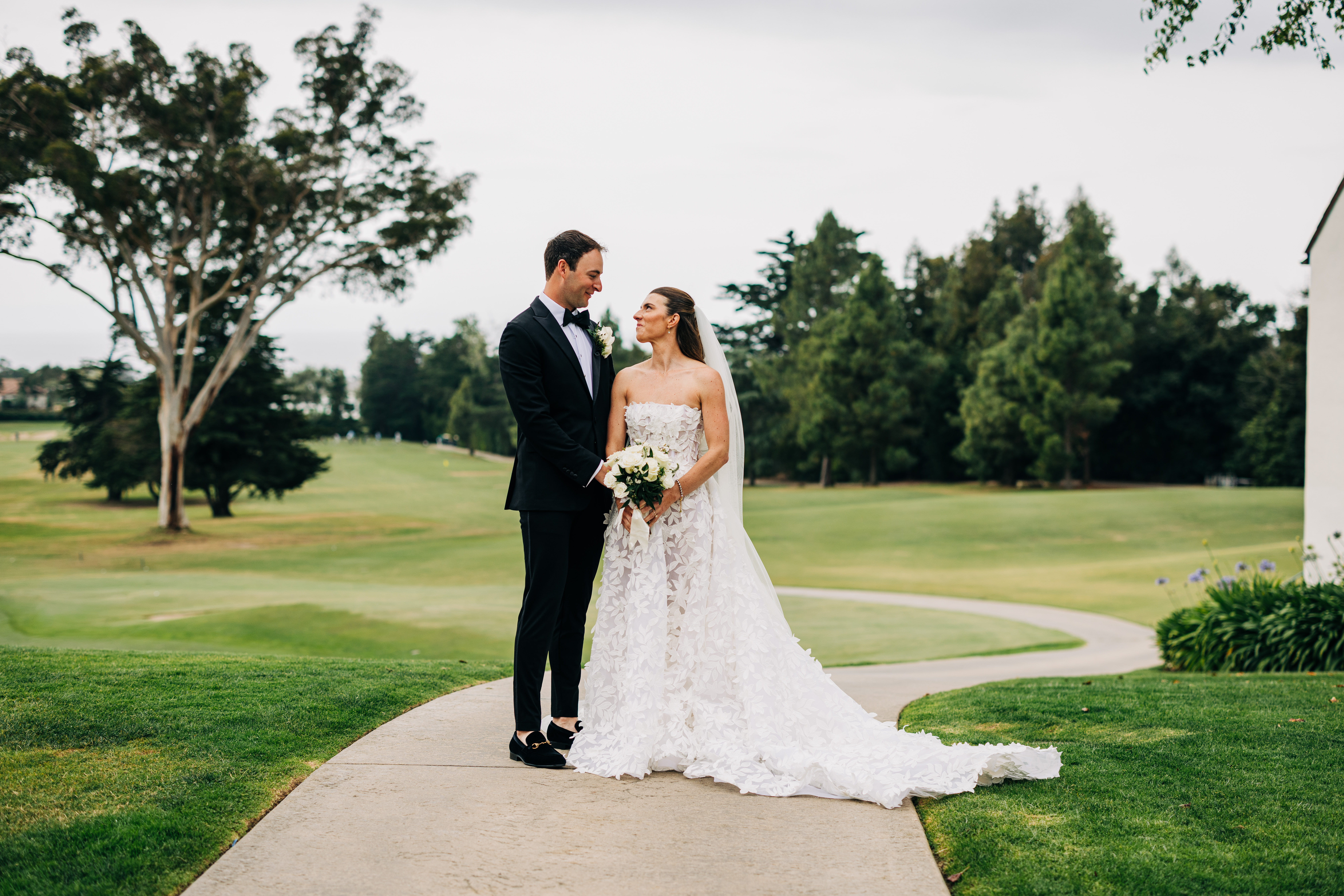 Bride and groom pose together on a golf course during their Santa Barbara wedding portraits.